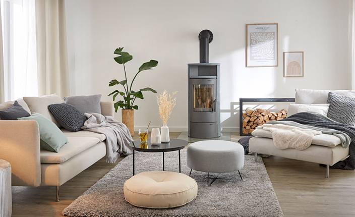 Gemütlich eingerichtetes Wohnzimmer mit farblich abgestimmten Sitzgelegenheiten und einem Kamin