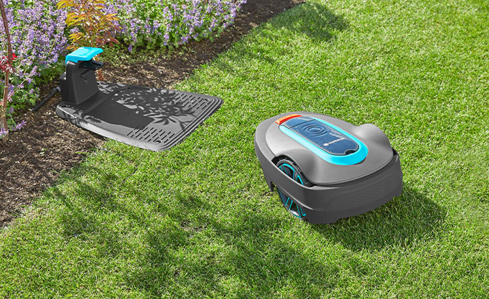 Ein Mähroboter fährt im Garten über den Rasen